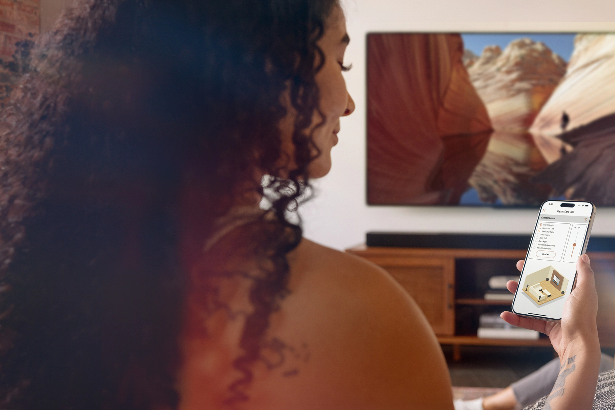 Женщина с колонками Klipsch Flexus использует приложение Klipsch Connect Plus для управления колонками Core 300 2000x1333
